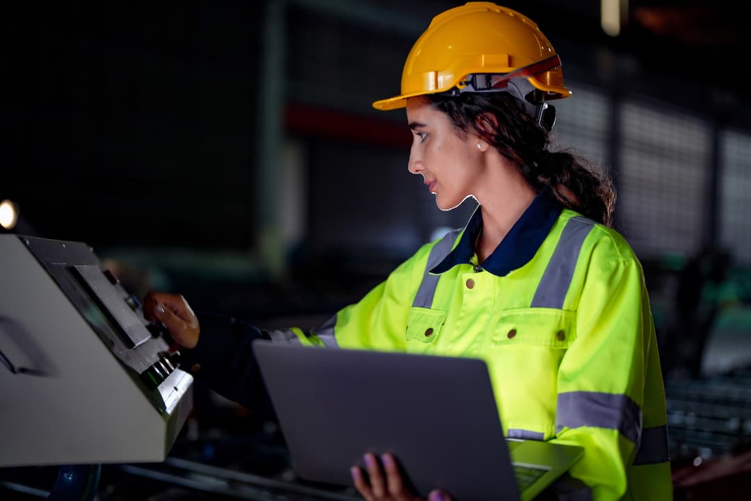Ingeniera eléctrica revisando planos en una tablet, protegida con equipo de seguridad de Ferreterías Guevara