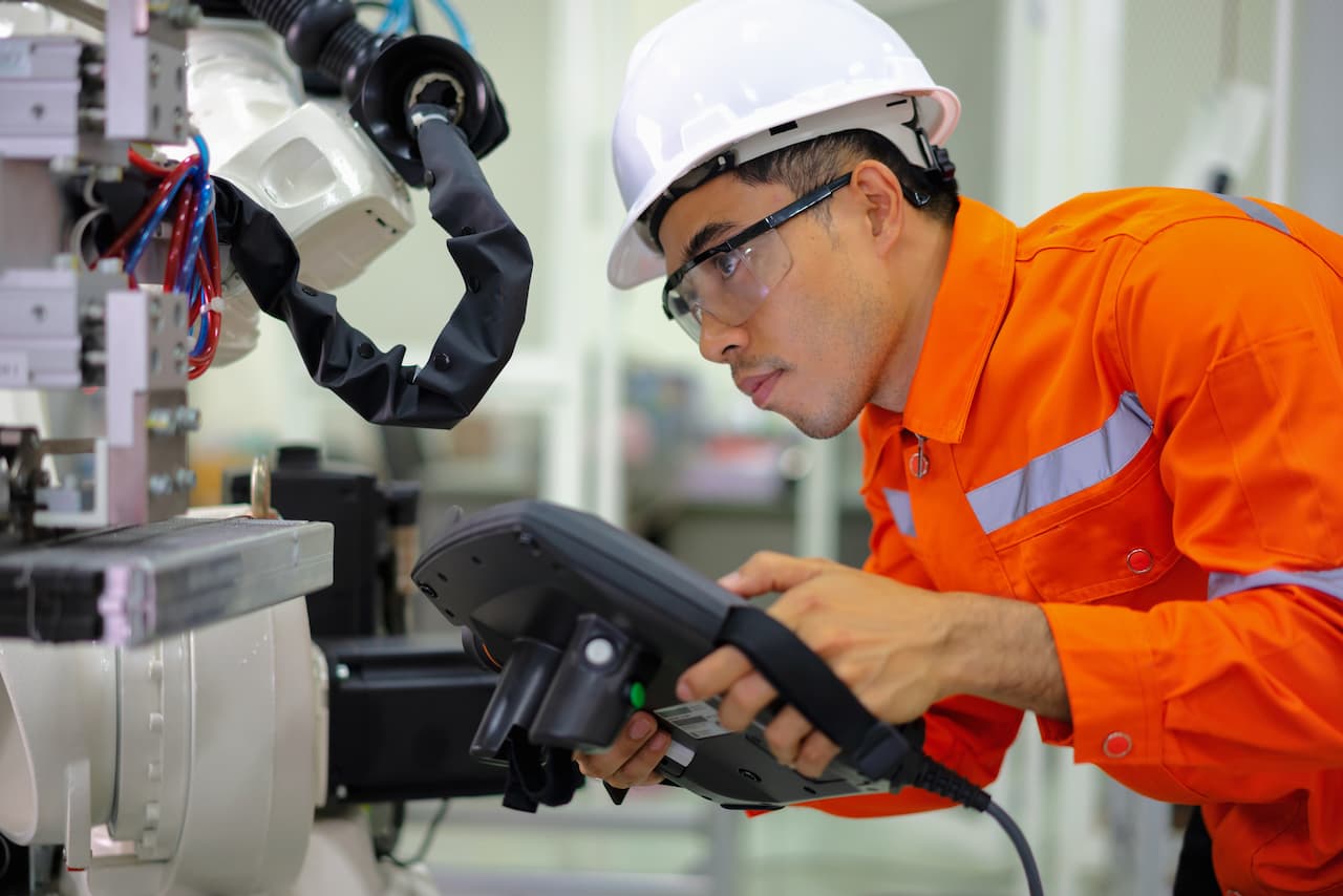 Ingeniero de mantenimiento revisando maquinaria con gafas protectoras y casco, asegurando la seguridad con productos de Ferreterías Guevara
