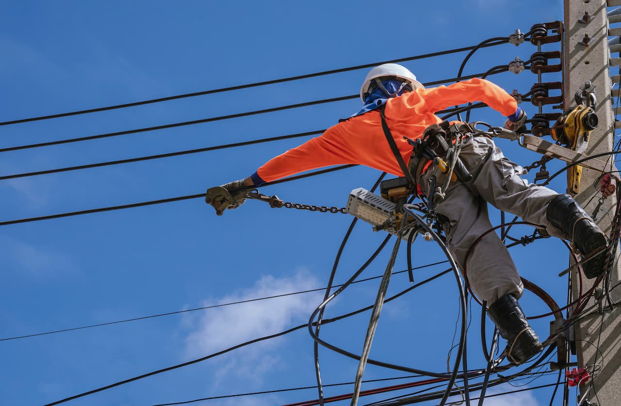 Trabajador en altura realizando mantenimiento eléctrico con equipo de seguridad de Ferreterías Guevara
