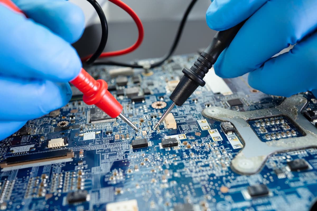 Trabajador ajustando conexiones eléctricas con guantes aislantes