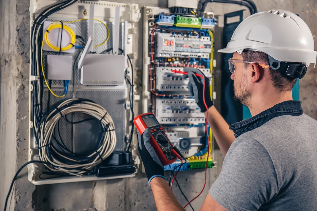 Trabajador con equipo de protección desconectando cables eléctricos