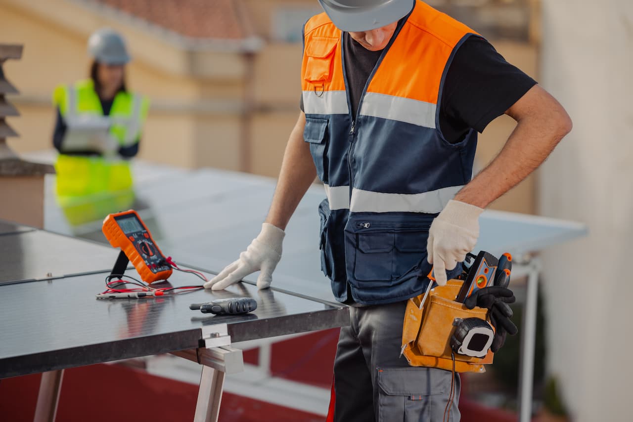 Trabajador eléctrico con chaleco reflectante y herramientas de protección, proporcionadas por Ferreterías Guevara