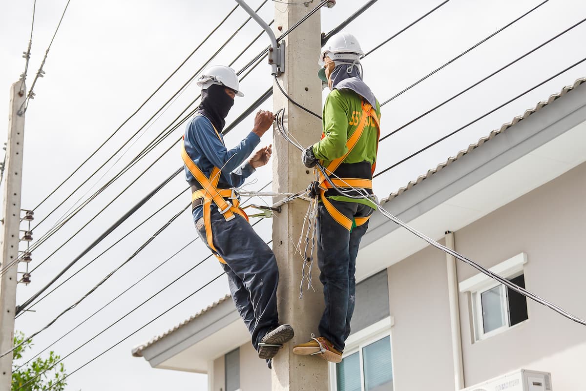 Trabajadores en un poste de electricidad con equipo de Ferreterías Guevara