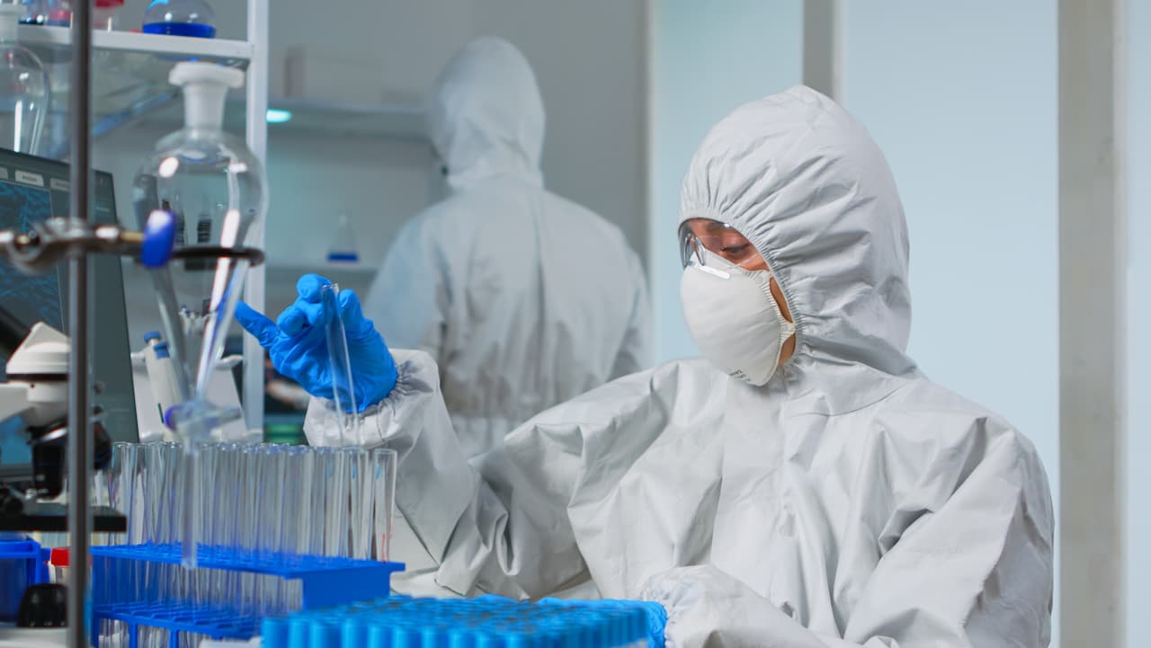 Operador en laboratorio industrial usando traje azul de seguridad, suministrado por Ferreterías Guevara