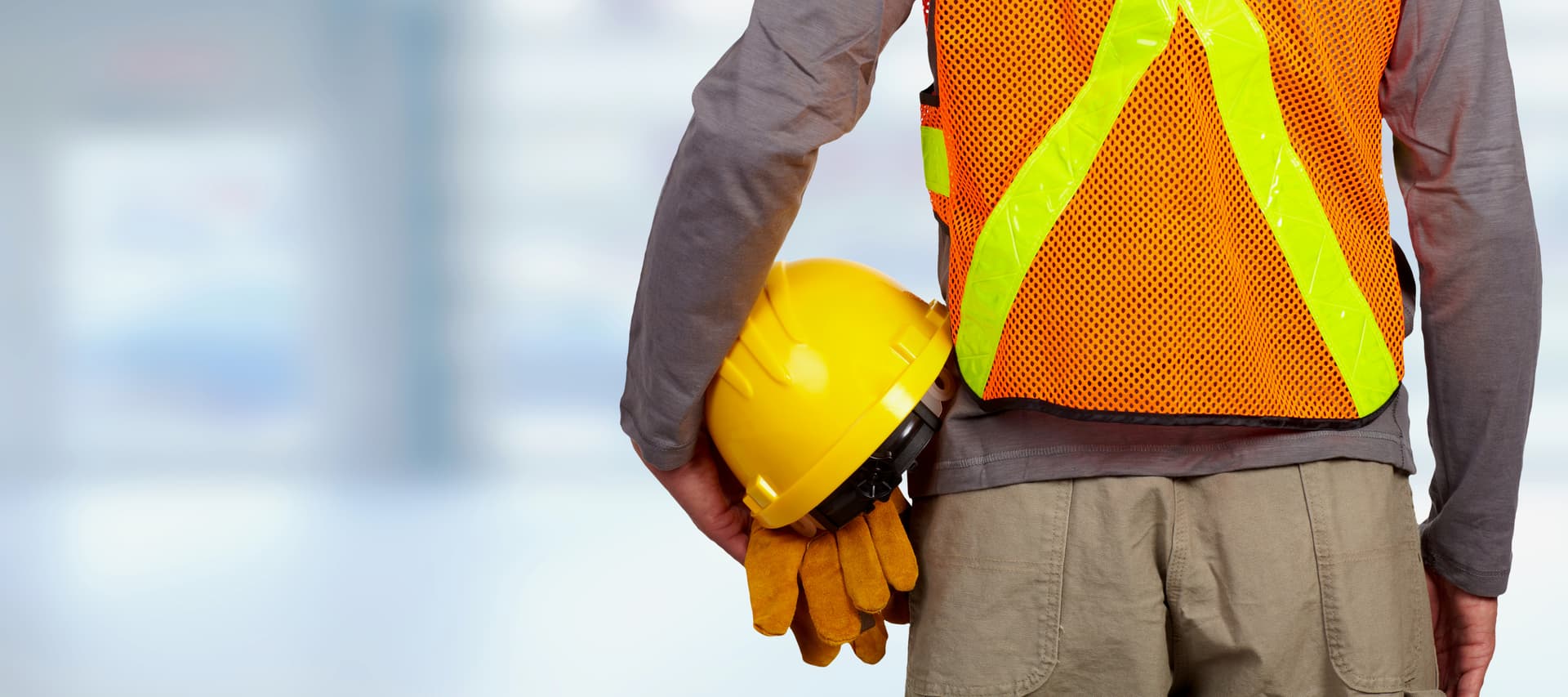 Trabajador sosteniendo casco y guantes de seguridad en Ferreterías Guevara en Monterrey