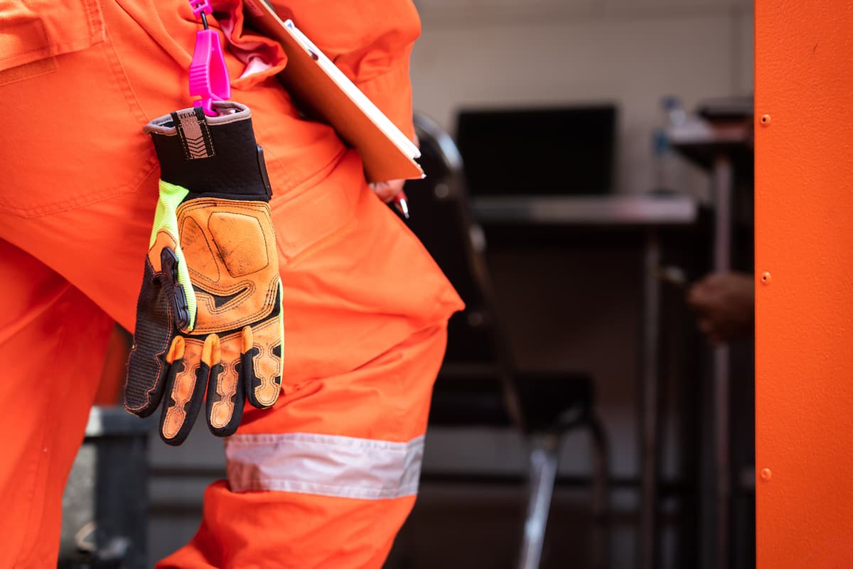 Guantes de seguridad de Ferreterías Guevara en el cinturón de un trabajador